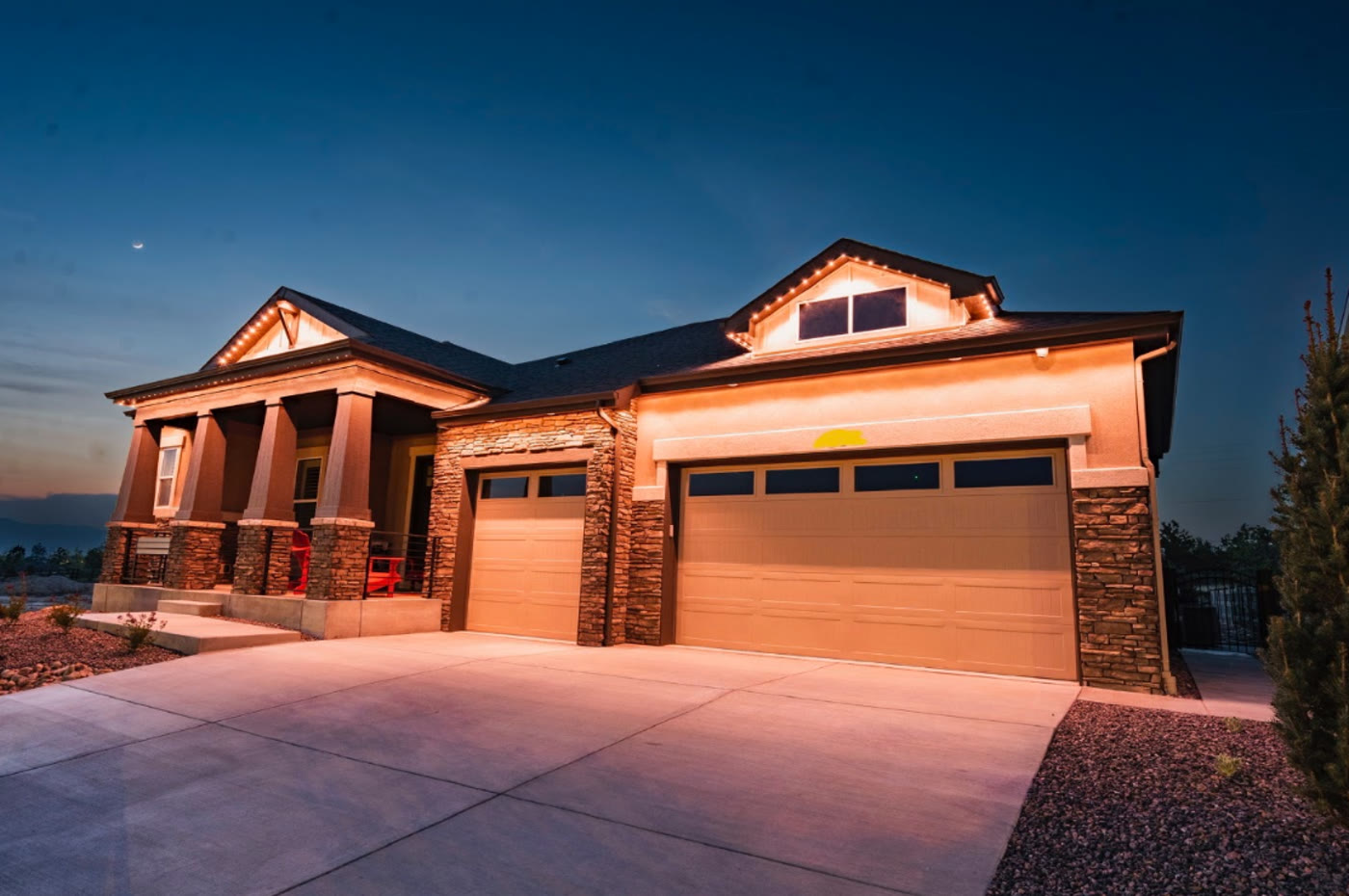 Warm exterior roofline lighting on a home at dusk