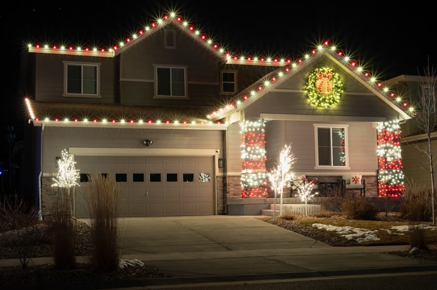 Home with seasonal Christmas lights installed on roofline and columns